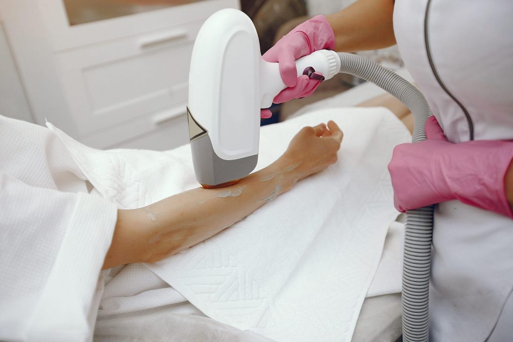 Cosmetologist use laser. Woman with cosmetologist. Lady in a beauty studio.